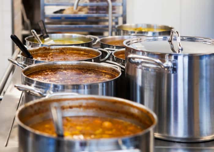 Various pots of soup in a commercial kitchen