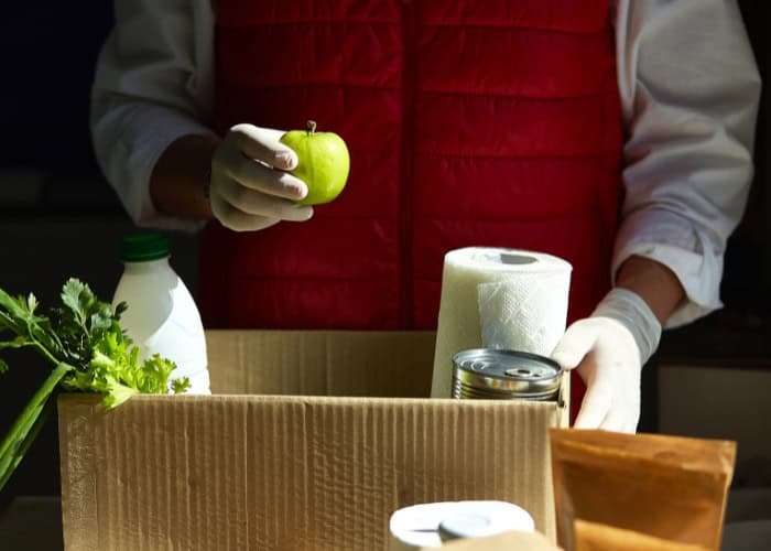 Volunteer packing a box of food and supplies